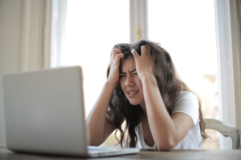 An Amazon seller sitting at her computer, frustrated by all the challenges she's encountering.