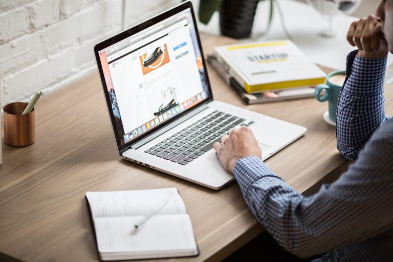 An Amazon seller sitting at his computer, thinking long and hard about which is better for his ecommerce business: an LLC or an S Corp?