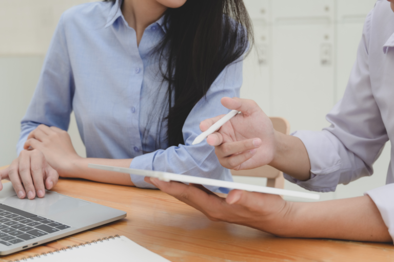 A businessman consulting with a businesswoman on how much she should be paying for payroll processing services.