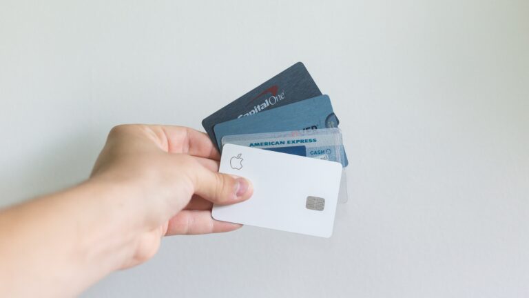 A person holding an assortment of U.S. credit cards.