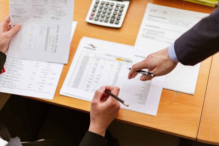 A photo of an accountant performing due diligence by reviewing a business owner's financial statements.